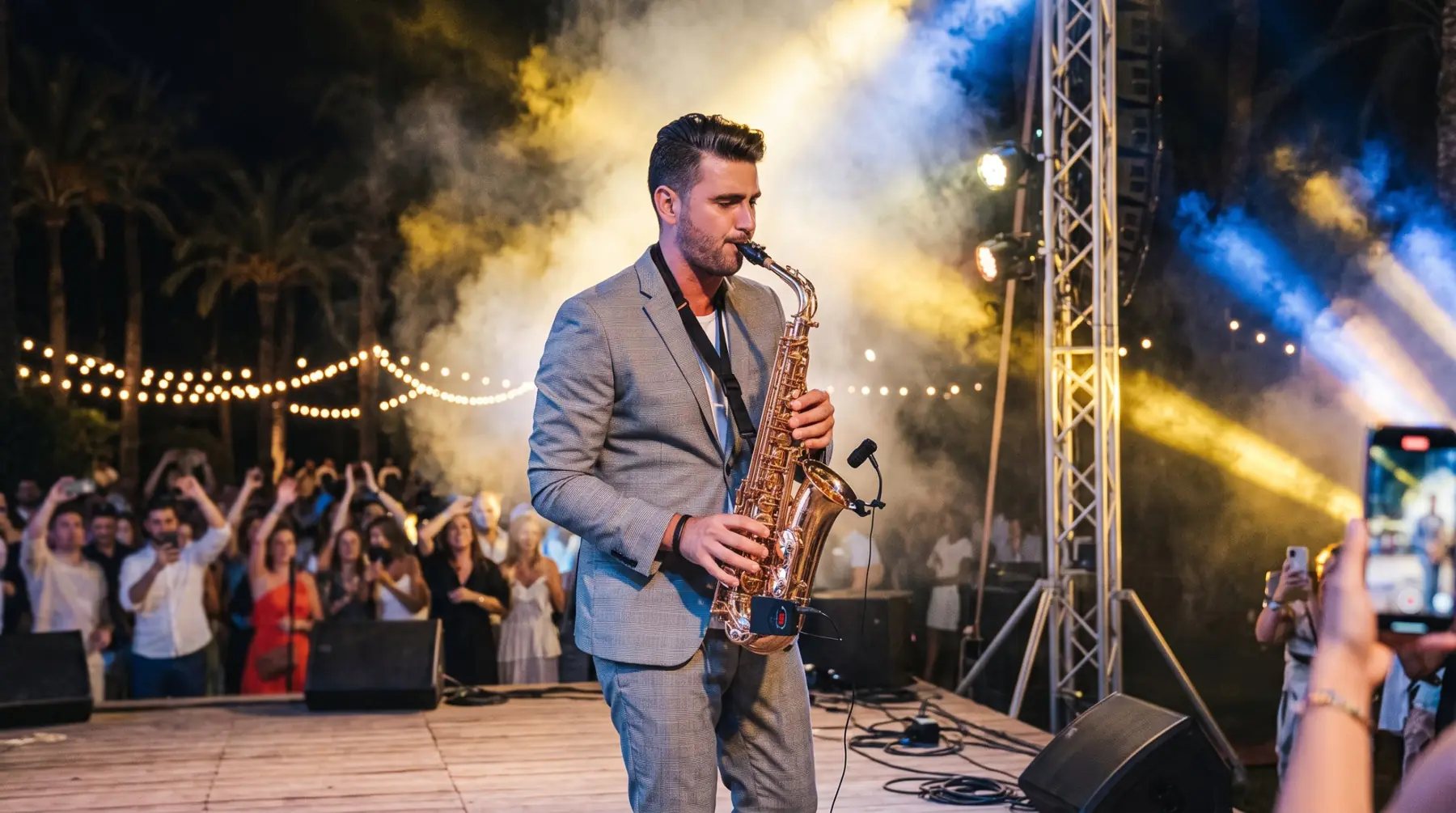 Saxofonista en un concierto nocturno con el público grabando