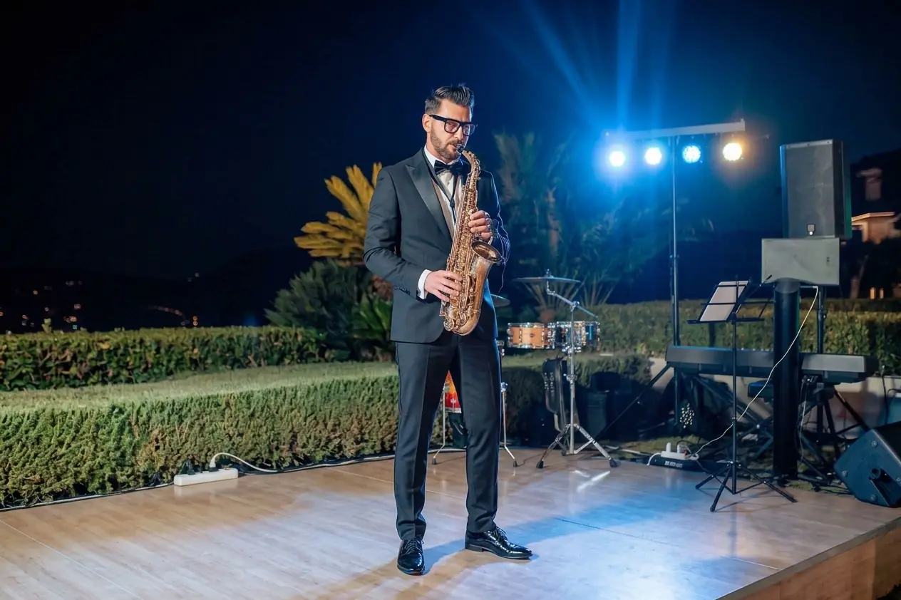 Saxofonista en esmoquin en una fiesta privada en una terraza